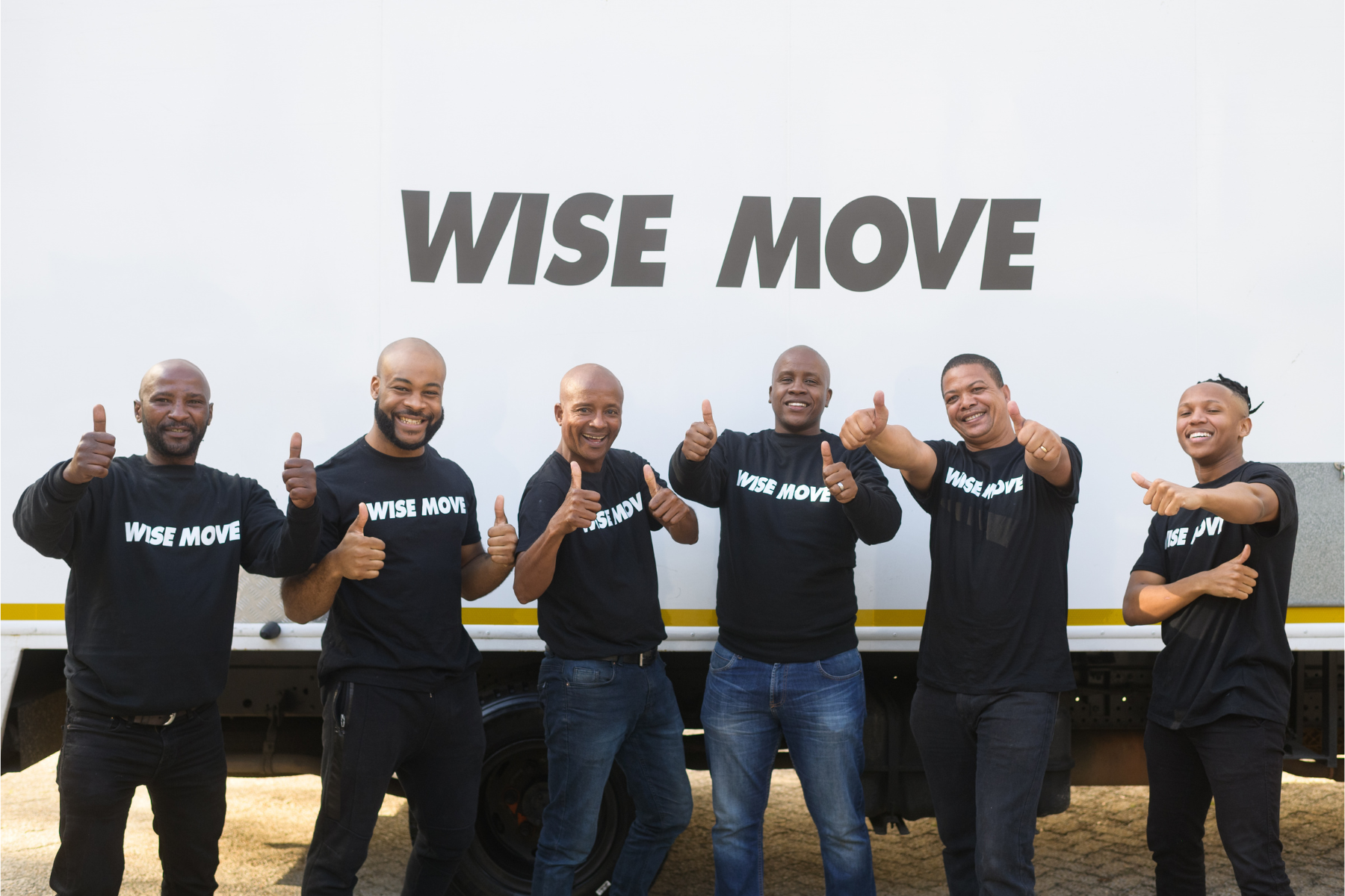 Wise Move team standing in front of moving truck with thumbs up