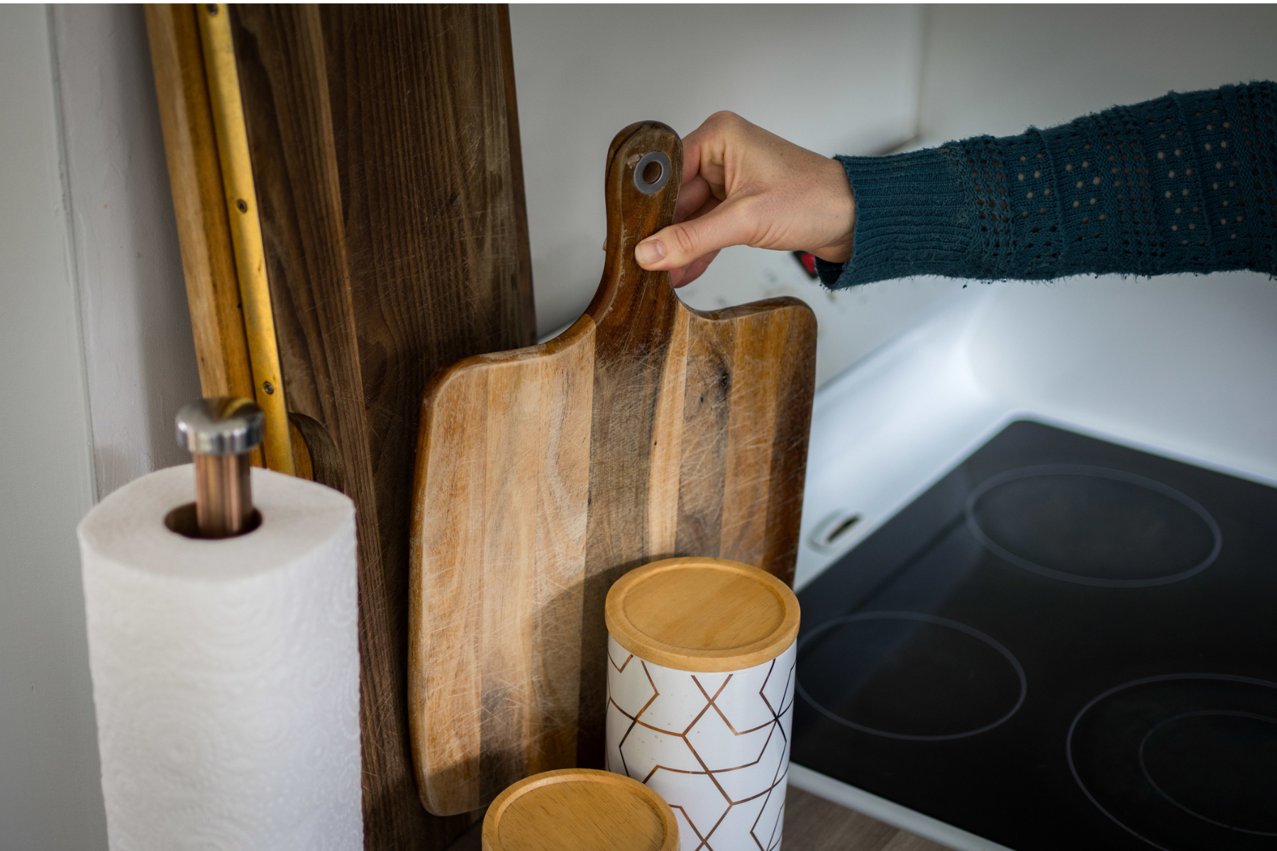 Hand putting chopping board out in kitchen to set up property for short-term rental