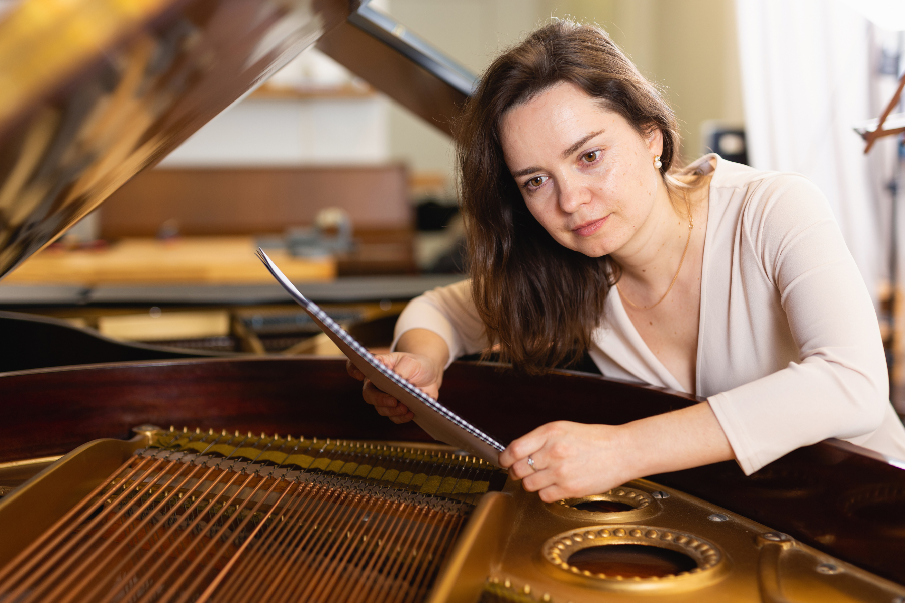 Woman buying second-hand piano using checklist to check tuning