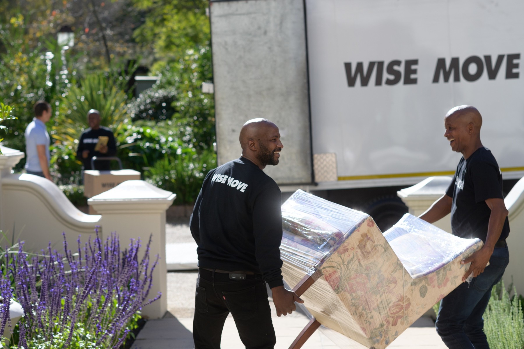 Wise Move team carrying second-hand vintage armchair into home