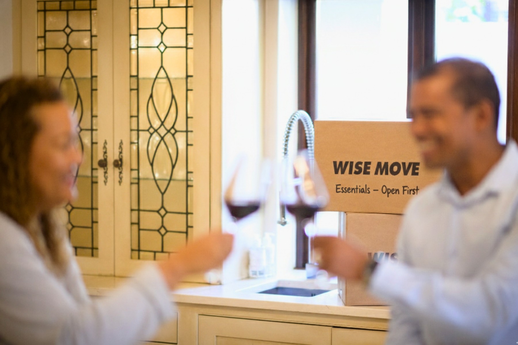 Couple cheering after moving in with essential open first box in the background